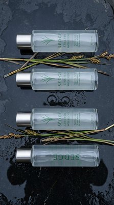 Elegant Sedge Skincare Bottles Displayed on Dark Surface